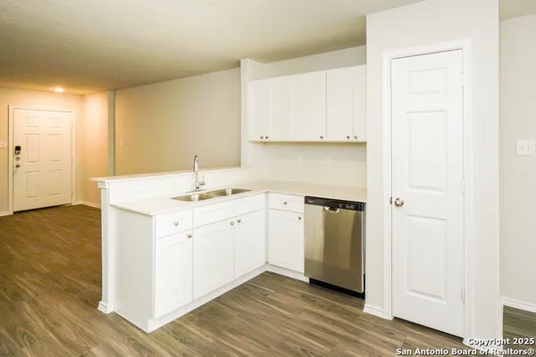 a kitchen with a sink cabinets and wooden floor
