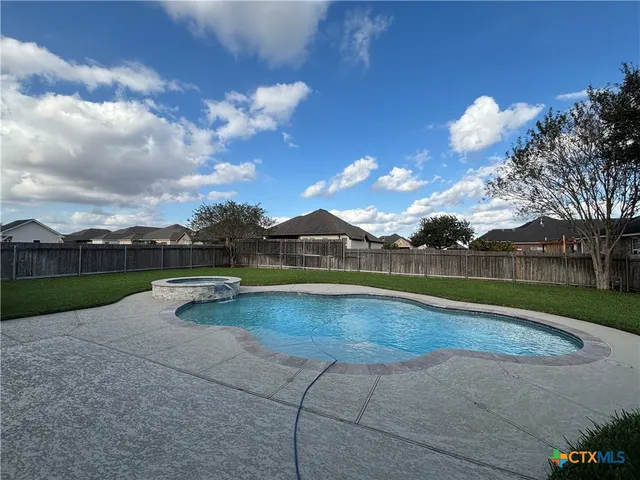 a view of a house with swimming pool and green space