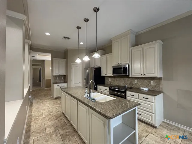 a kitchen with stainless steel appliances granite countertop a sink a stove and a refrigerator