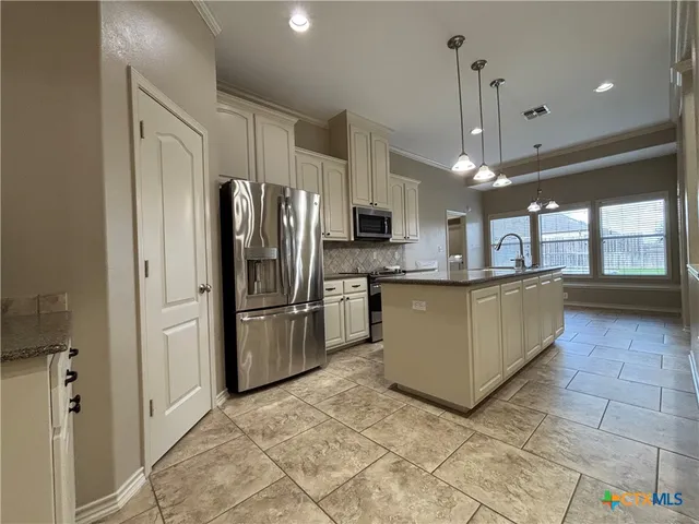 a kitchen with stainless steel appliances a refrigerator sink and cabinets