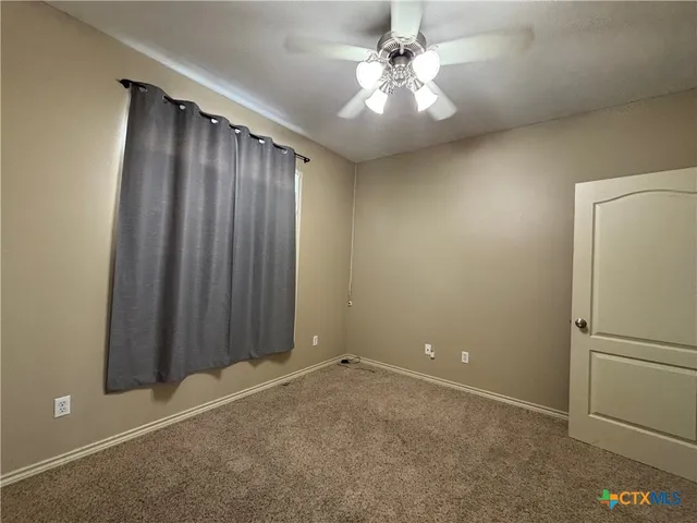 an empty room with a ceiling fan and a fan