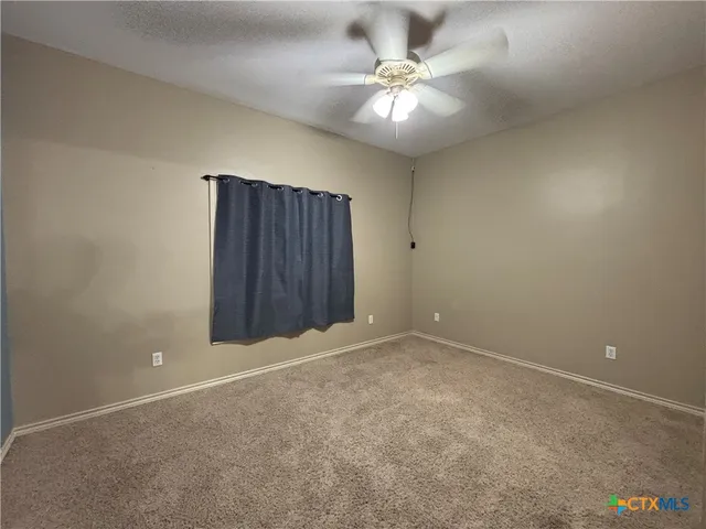an empty room with a chandelier fan