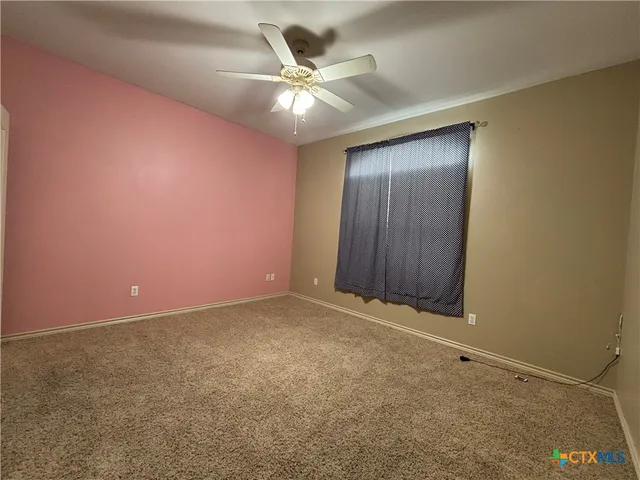 an empty room with a ceiling fan and closet