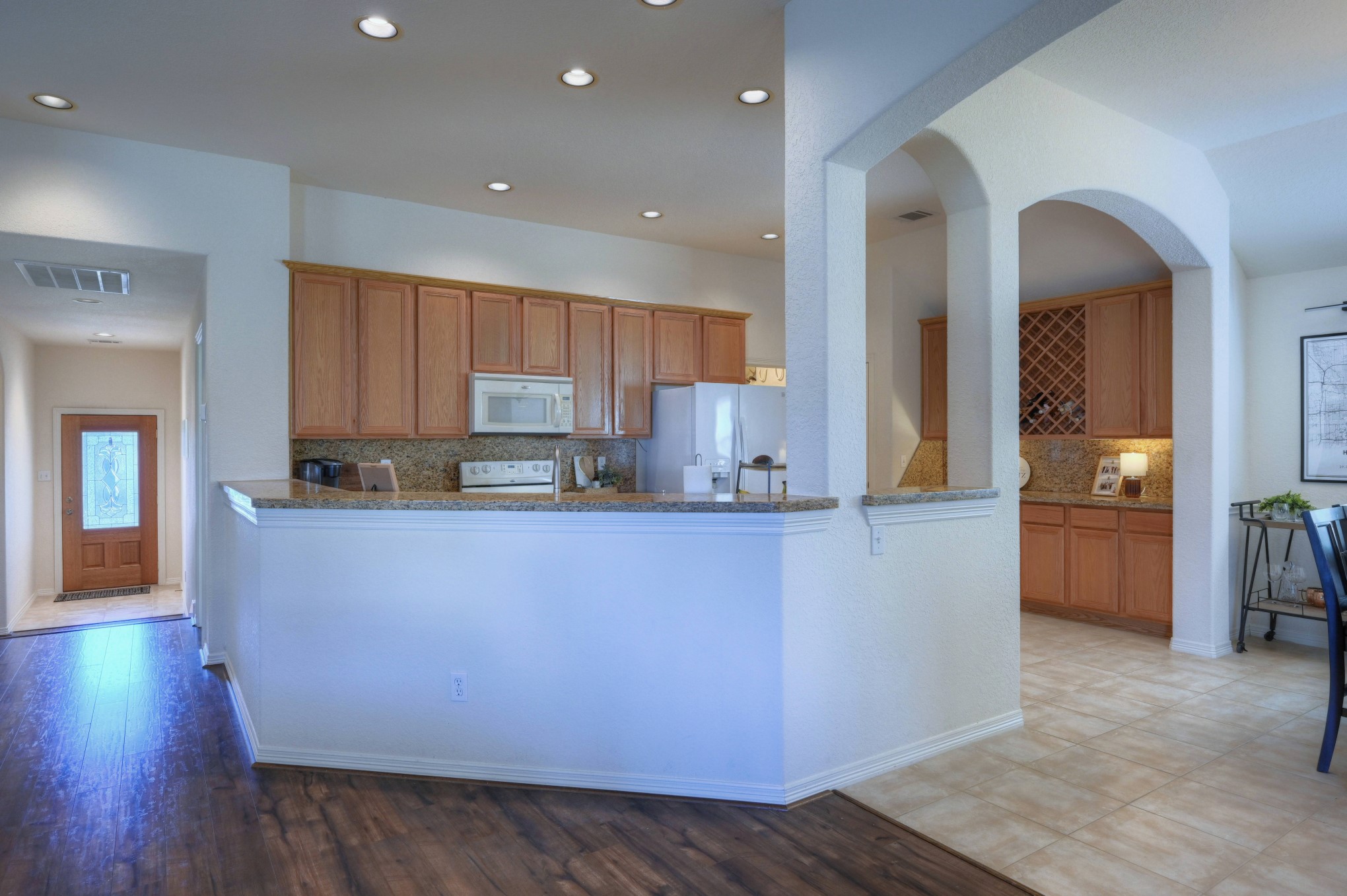 108 Cove Circle Conroe, TX 77356 - Photo 15 of 50 A generously sized wrap-around bar takes center stage, anchoring the space with both style and functionality. This inviting feature not only provides ample counter space for meal preparation but also serves as a sociable hub, perfect for casual dining and entertaining.