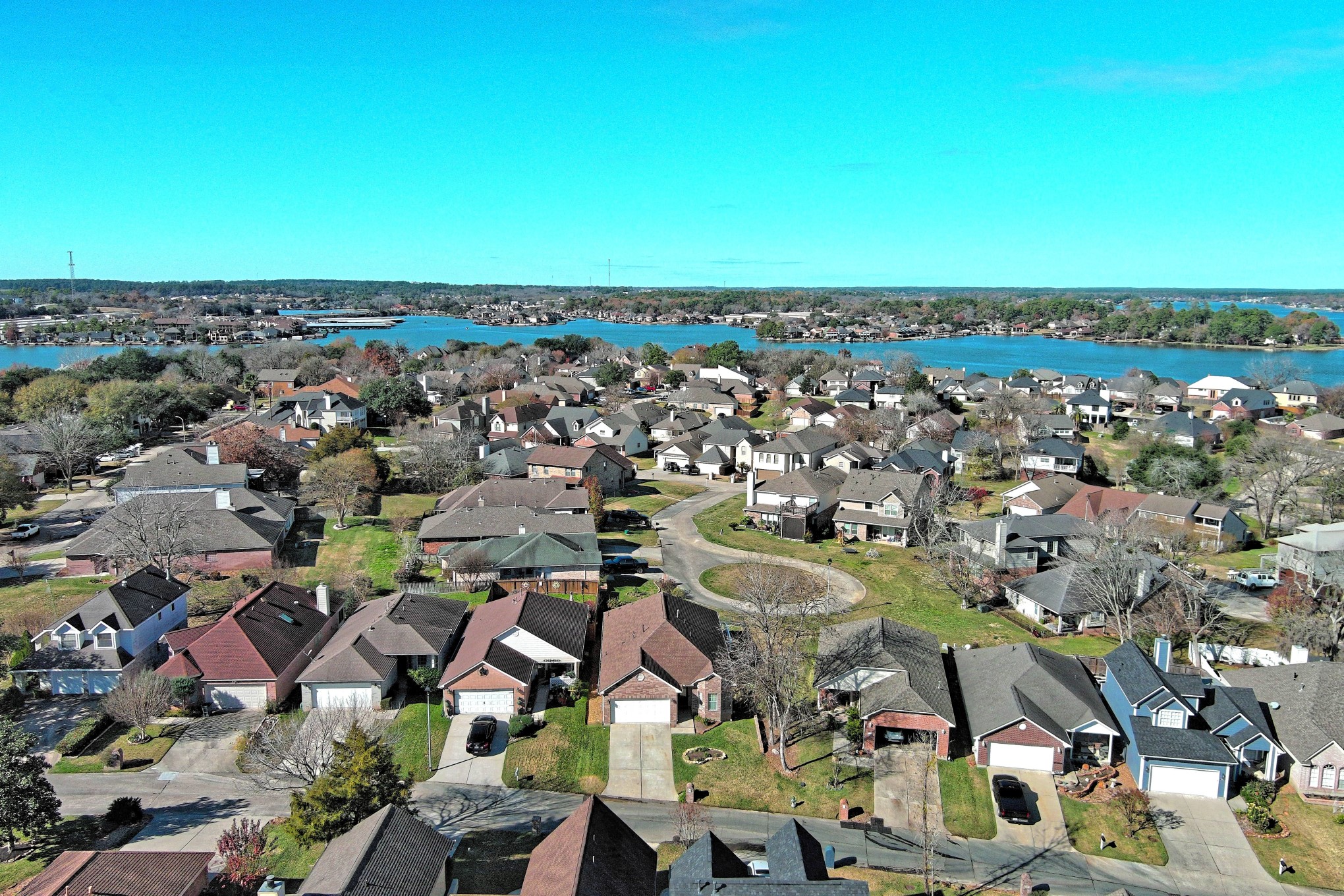 108 Cove Circle Conroe, TX 77356 - Photo 50 of 50 Soar above the residence in this captivating aerial view, revealing not only the home but also its enticing proximity to the picturesque Lake Conroe. Seize the opportunity to make this ideal retreat yours – schedule a viewing today!