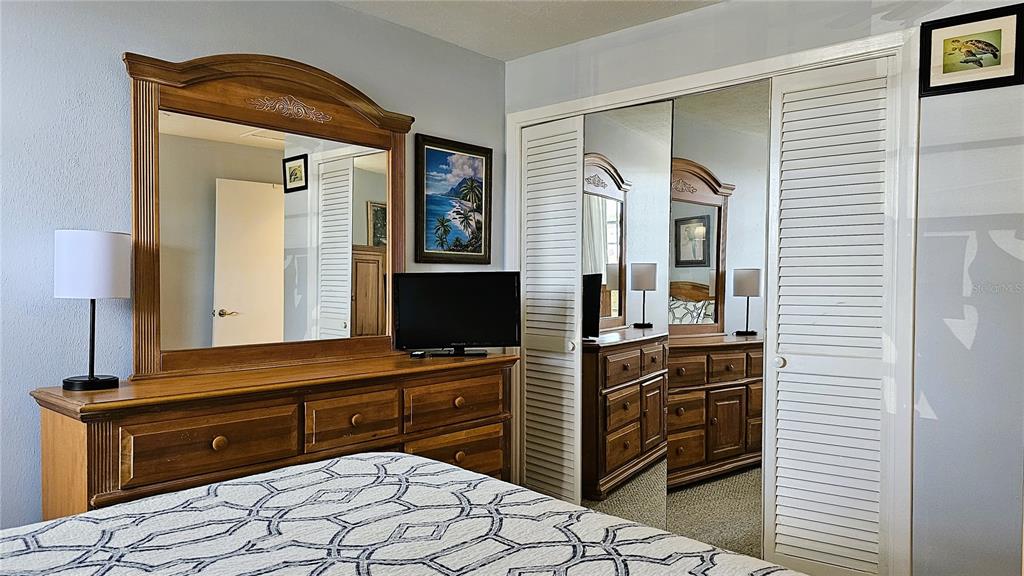 4318 Tahitian Gardens Circle, Unit B Holiday, FL 34691 - Photo 20 of 28 a bedroom with a bed and a flat tv screen on dresser