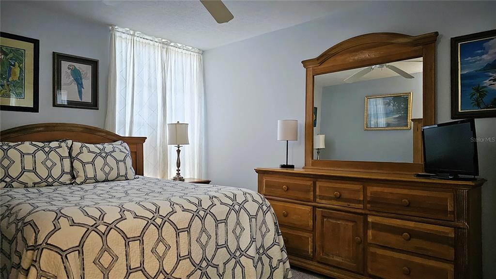 4318 Tahitian Gardens Circle, Unit B Holiday, FL 34691 - Photo 21 of 28 a bedroom with a bed and a flat tv screen on dresser