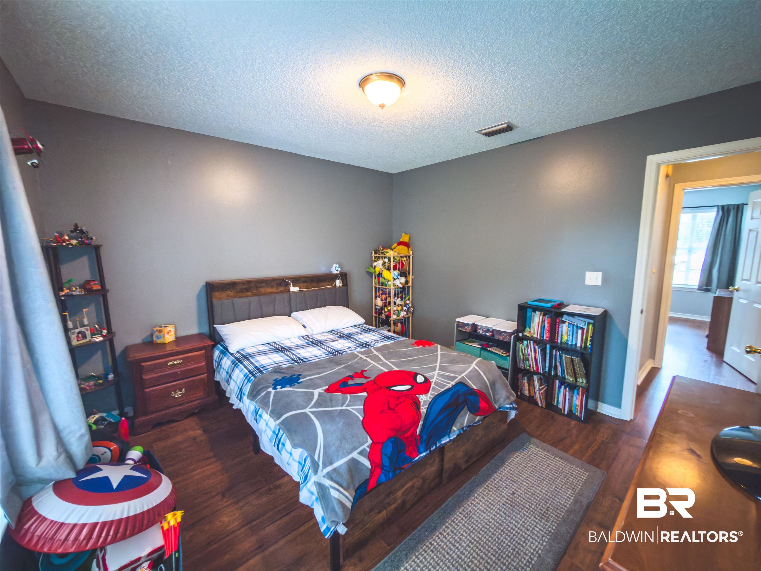 129 Pennbrooke Loop Foley, AL 36535 - Photo 17 of 44 Bedroom featuring dark wood finished floors and a textured ceiling