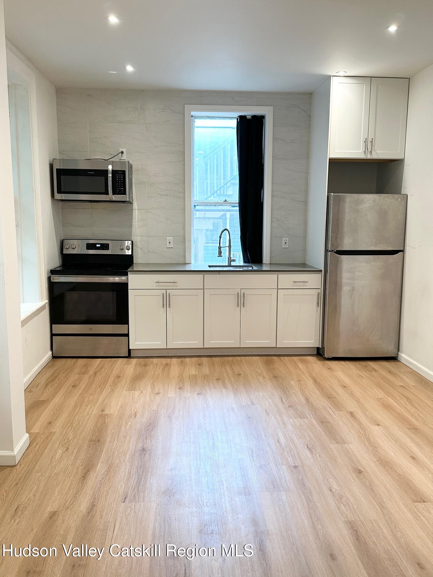 466 Main Street, Unit 3 Catskill, NY 12414 - Photo 2 of 7 a kitchen with stainless steel appliances granite countertop a refrigerator a stove and a wooden floors