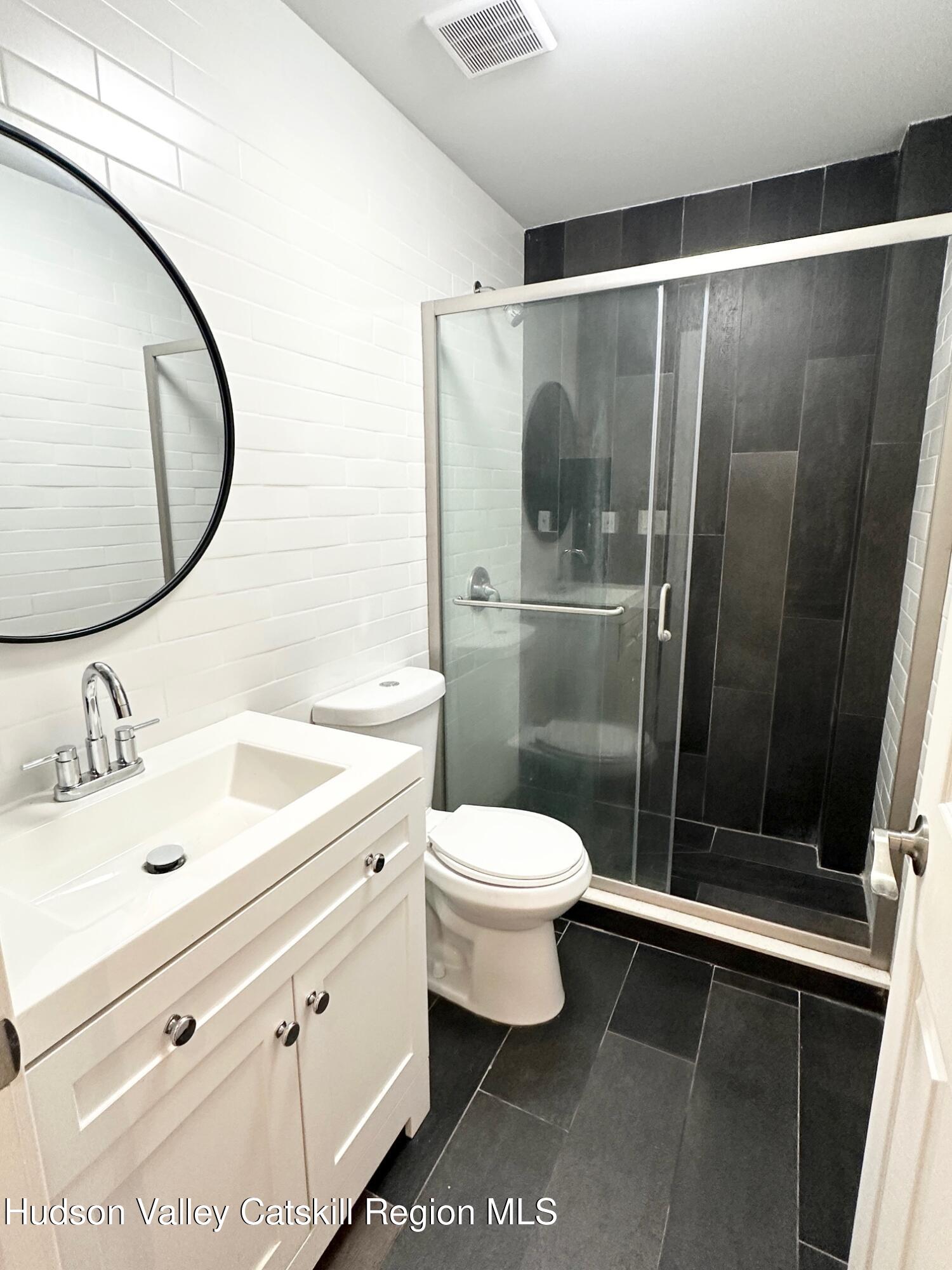 466 Main Street, Unit 3 Catskill, NY 12414 - Photo 4 of 7 a bathroom with a sink and a mirror