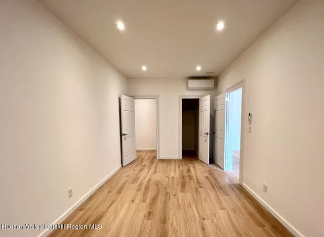 a view of hallway with a large window and wooden floor