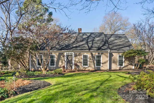 a view of a backyard with wooden fence and large trees