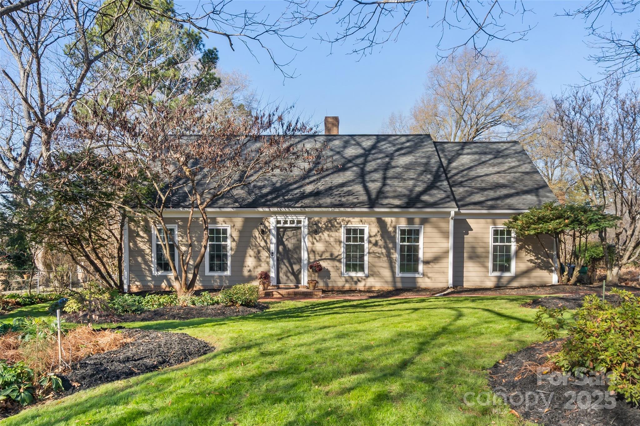 a view of a backyard with wooden fence and large trees