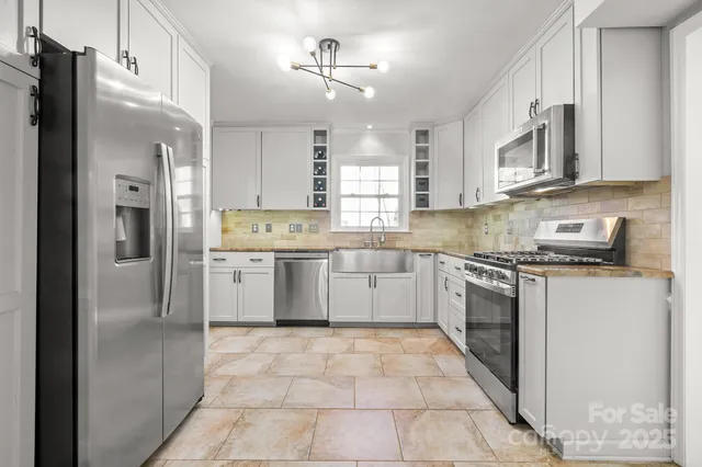 a kitchen with stainless steel appliances granite countertop a refrigerator a sink dishwasher a stove with wooden cabinets and floor