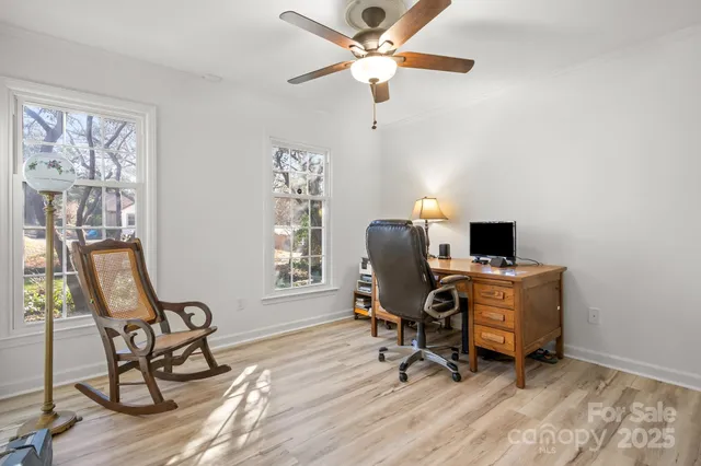 a view of a workspace with furniture and a window