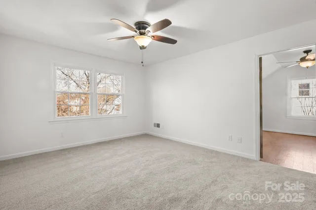 an empty room with chandelier fan