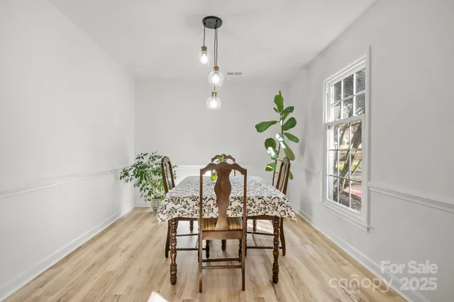 a dining room with furniture potted plants and wooden floor