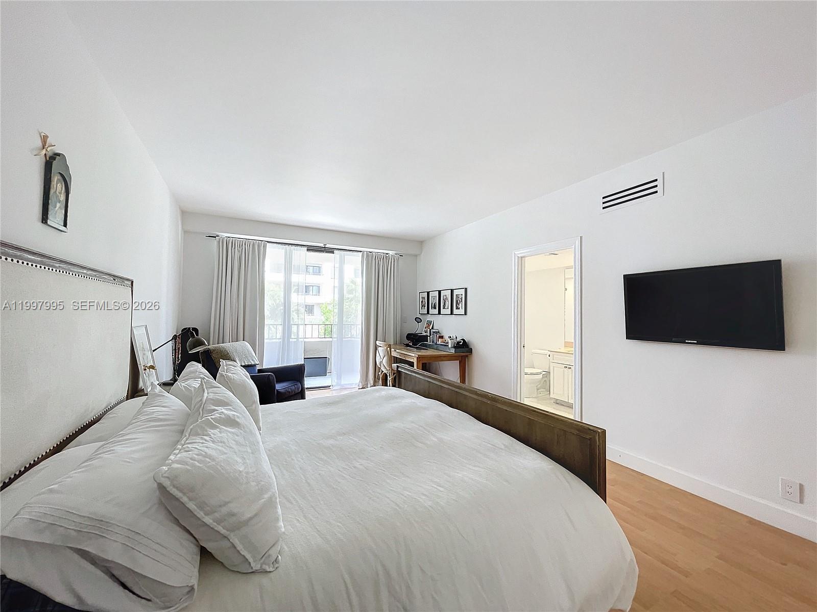 Key Colony Condominiums Key Biscayne, FL 33149 - Photo 15 of 29 a large bedroom with a bed and a flat screen tv