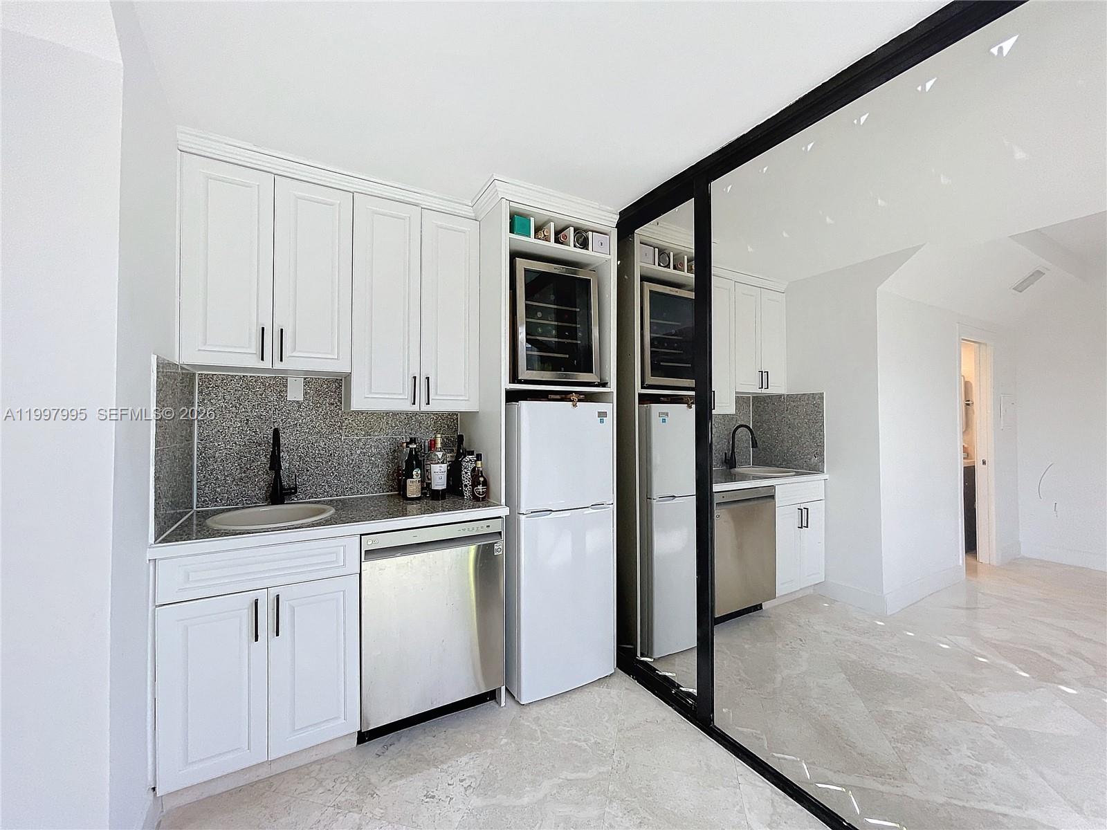 Key Colony Condominiums Key Biscayne, FL 33149 - Photo 26 of 29 a kitchen with white cabinets and stainless steel appliances