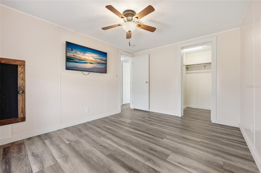 7119 Northeast 24th Loop High Springs, FL 32643 - Photo 22 of 35 a view of an empty room with wooden floor and a ceiling fan