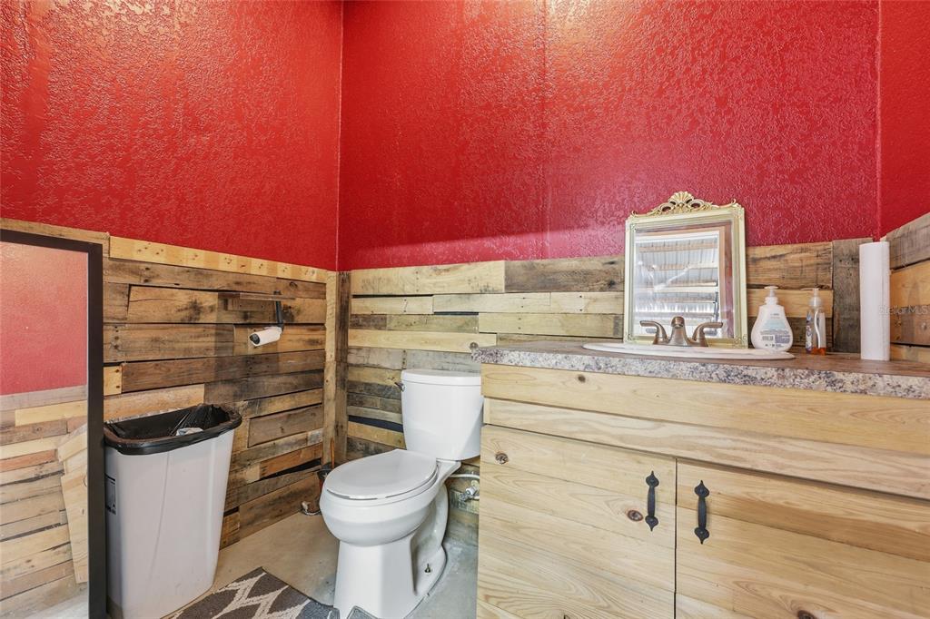 7119 Northeast 24th Loop High Springs, FL 32643 - Photo 27 of 35 a bathroom with a toilet a sink and mirror