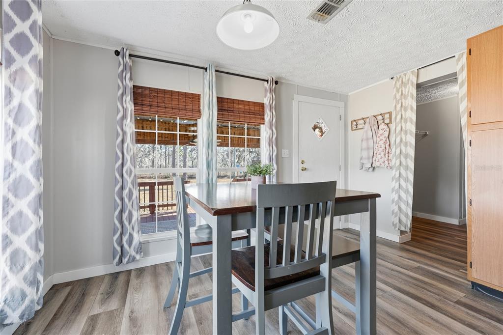 7119 Northeast 24th Loop High Springs, FL 32643 - Photo 8 of 35 a view of a dining room with furniture and wooden floor