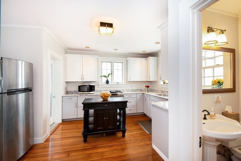 6 Oceanside Drive Scituate, MA 02066 - Photo 15 of 34 a kitchen with refrigerator cabinets and wooden floor