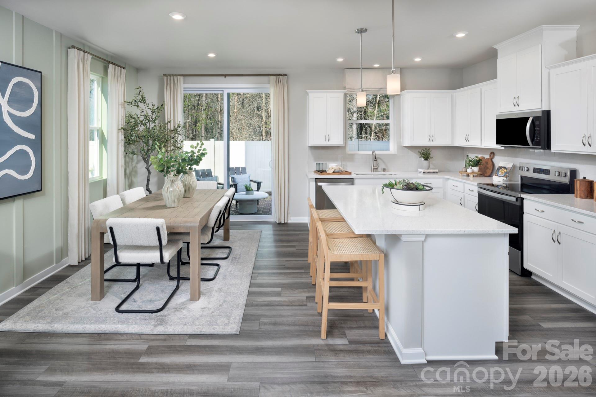 344 Laura Elizabeth Lane Clover, SC 29710 - Photo 4 of 19 a kitchen with stainless steel appliances kitchen island granite countertop a stove a sink a microwave a dining table and chairs