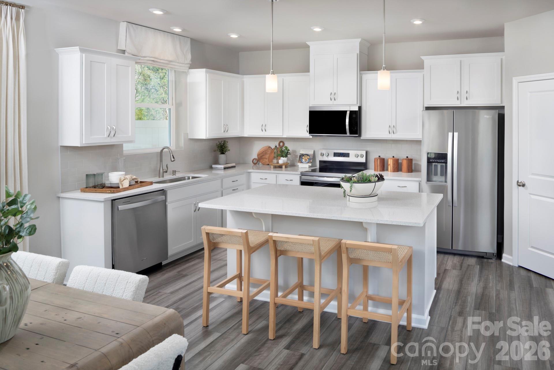 344 Laura Elizabeth Lane Clover, SC 29710 - Photo 6 of 19 a kitchen with stainless steel appliances a stove a sink a refrigerator and a dining table with wooden floor