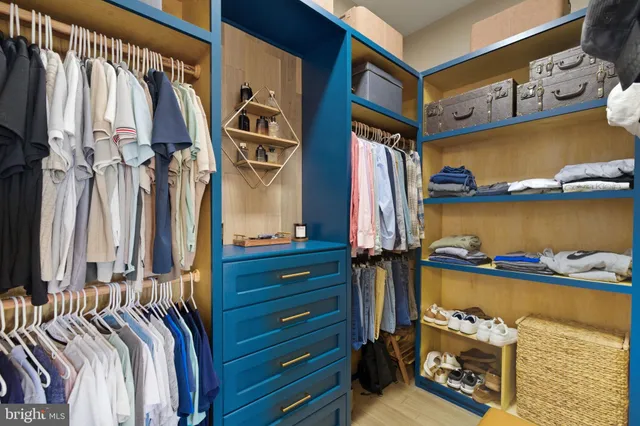 a view of walk in closet with clothes and shoes