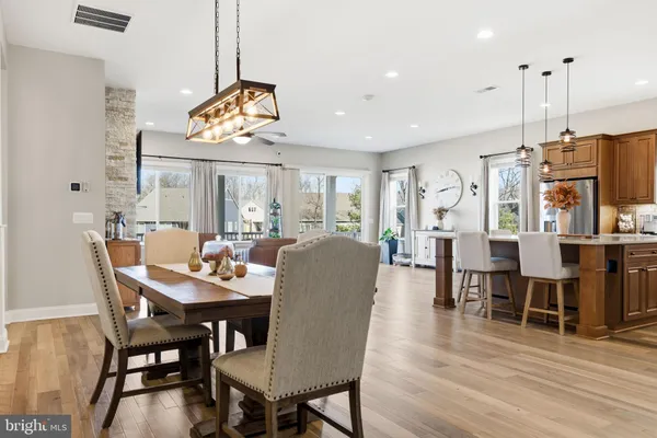 a view of a dining room and livingroom with furniture wooden floor a chandelier