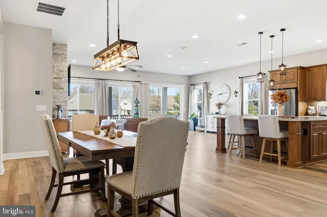 a view of a dining room and livingroom with furniture wooden floor a chandelier