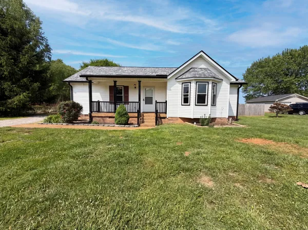 a front view of a house with a yard and trees