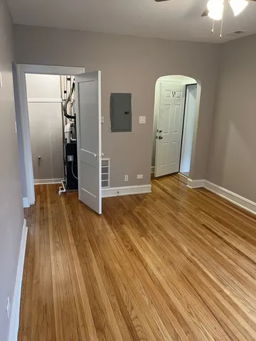 a view of a livingroom with wooden floor and a ceiling fan