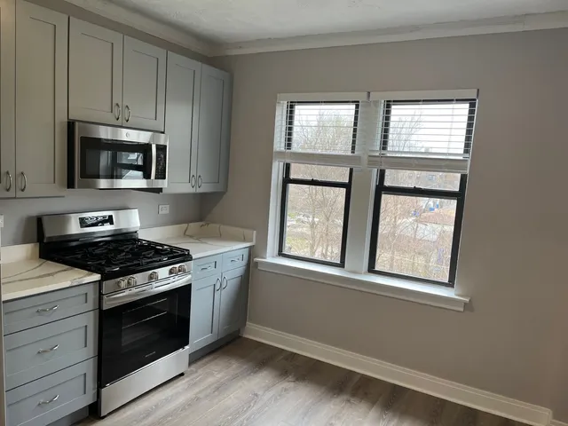 a kitchen with stainless steel appliances granite countertop a stove a microwave and window