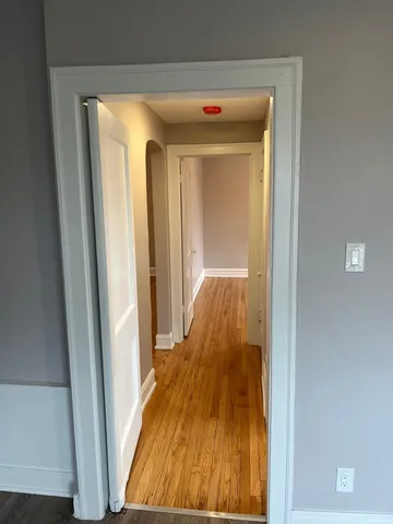 a view of a hallway with wooden floor