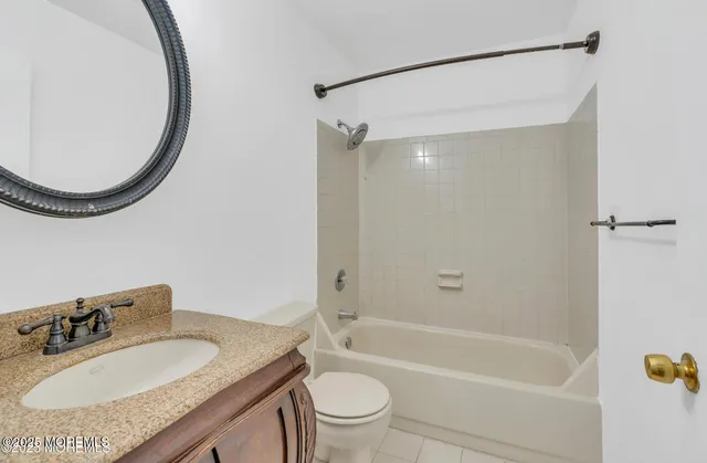a bathroom with a granite countertop sink a toilet and a mirror