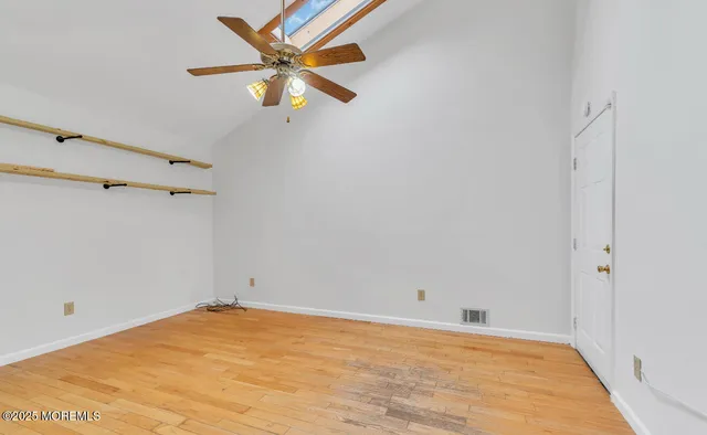 a view of a big room with wooden floor and a ceiling fan