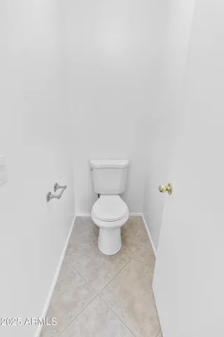 a white toilet sitting next to a white wall