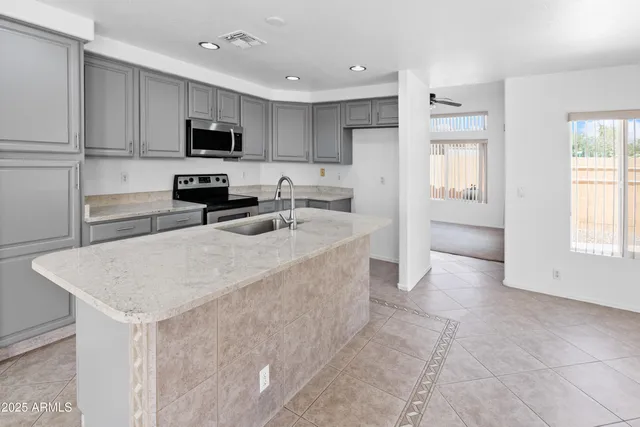 a kitchen with stainless steel appliances a sink a stove a microwave and cabinets