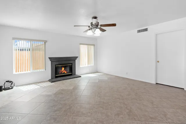 a view of empty room with a fireplace and fan