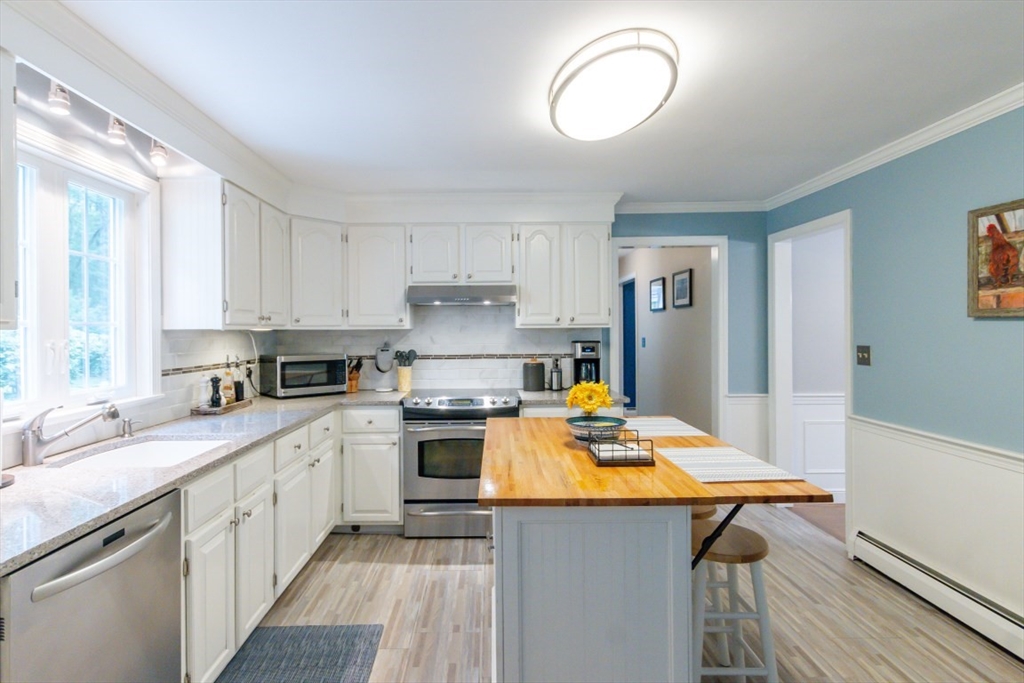 64 Wayside Inn Road Marlborough, MA 01752 - Photo 19 of 42 a kitchen with a sink a stove cabinets and wooden floor