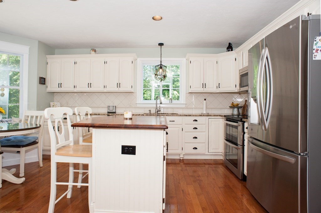53 Armsby Road Sutton, MA 01590 - Photo 13 of 42 a kitchen with white cabinets and stainless steel appliances