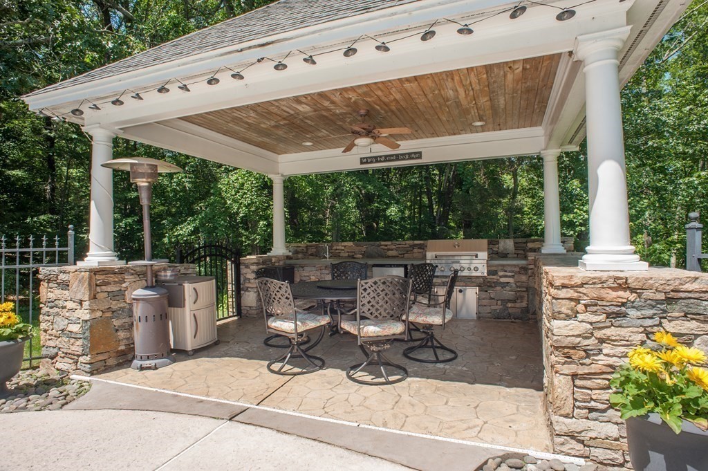 53 Armsby Road Sutton, MA 01590 - Photo 30 of 42 a view of a patio with table and chairs potted plants with floor to ceiling window