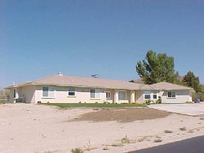 19564 Shasta Road Apple Valley, CA 92307 - Photo 1 of 1 a front view of a house with a road