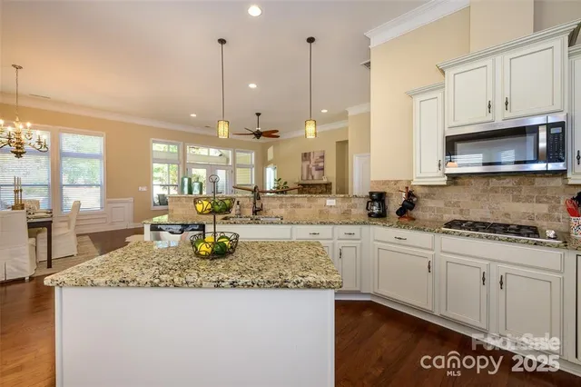 a kitchen with granite countertop a sink a stove and cabinets