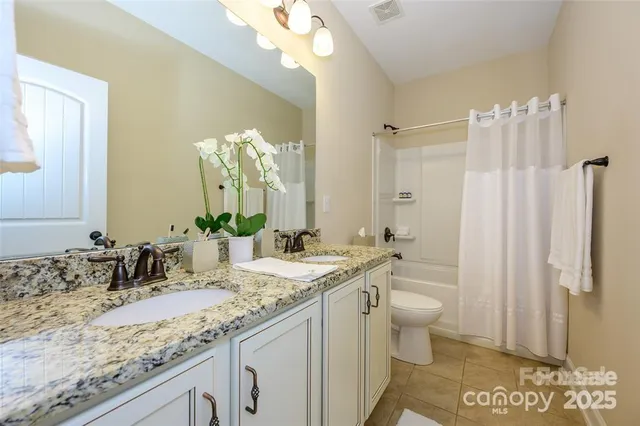a bathroom with a granite countertop sink a toilet and a mirror