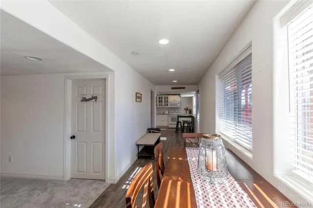 a kitchen with stainless steel appliances kitchen island granite countertop a refrigerator a stove and a dining table with wooden floor