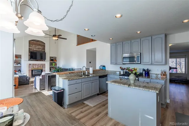 a kitchen with kitchen island granite countertop a sink cabinets and wooden floor