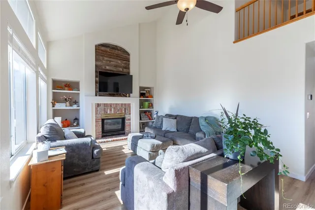 a living room with furniture a fireplace and a flat screen tv